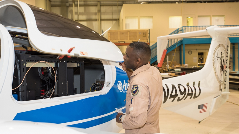 Tom Washington, a pilot, was aboard for the test flights to comply with federal airspace regulations, but the aircraft was operated from the flight control center on the ground. Here he checks out the gravimeter, which measures and records the gravity data. 
