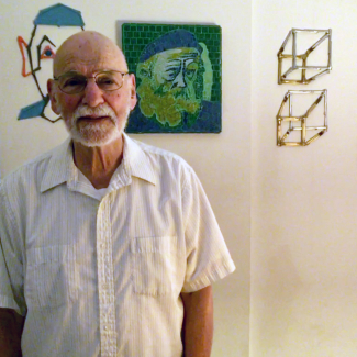 Jerome "Nick" Heffter stands before an art display.