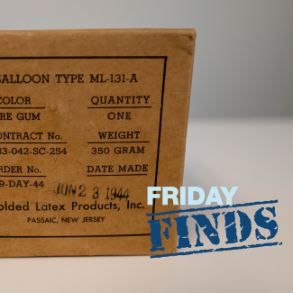 Photo of a small box labeled, “BALLOON TYPE ML-131-A”, COLOR: PURE GUM, QUANTITY: ONE, CONTRACT No.: W-33-042-SC-254, WEIGHT: 350 GRAM, ORDER No.: 289-DAY-44, DATE MADE: JUN 23 1944 (stamped on), Molded Latex Products, Inc., PASSAIC, NEW JERSEY"