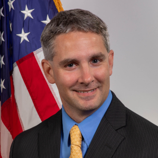 Photo of Dr. Steve Thur in front of an American flag