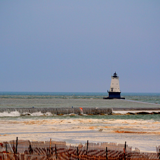 A Lake Michigan meteotsunami on April 13, 2018 unleashes a waterfall that cascades over the breakwater during the event near the lighthouse off Ludington, Michigan. 