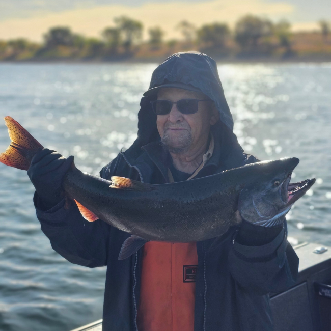 Craig holds a large fish while standing on a boat.